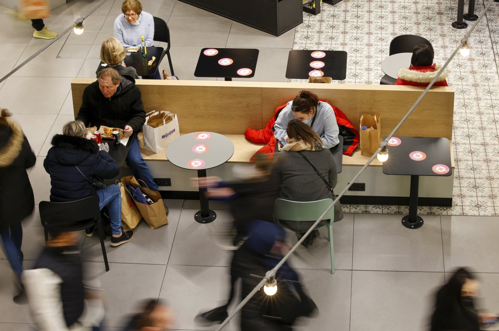 People have a snack in a shopping mall in Brussels, Belgium, Nov. 27, 2021. (AP Photo)