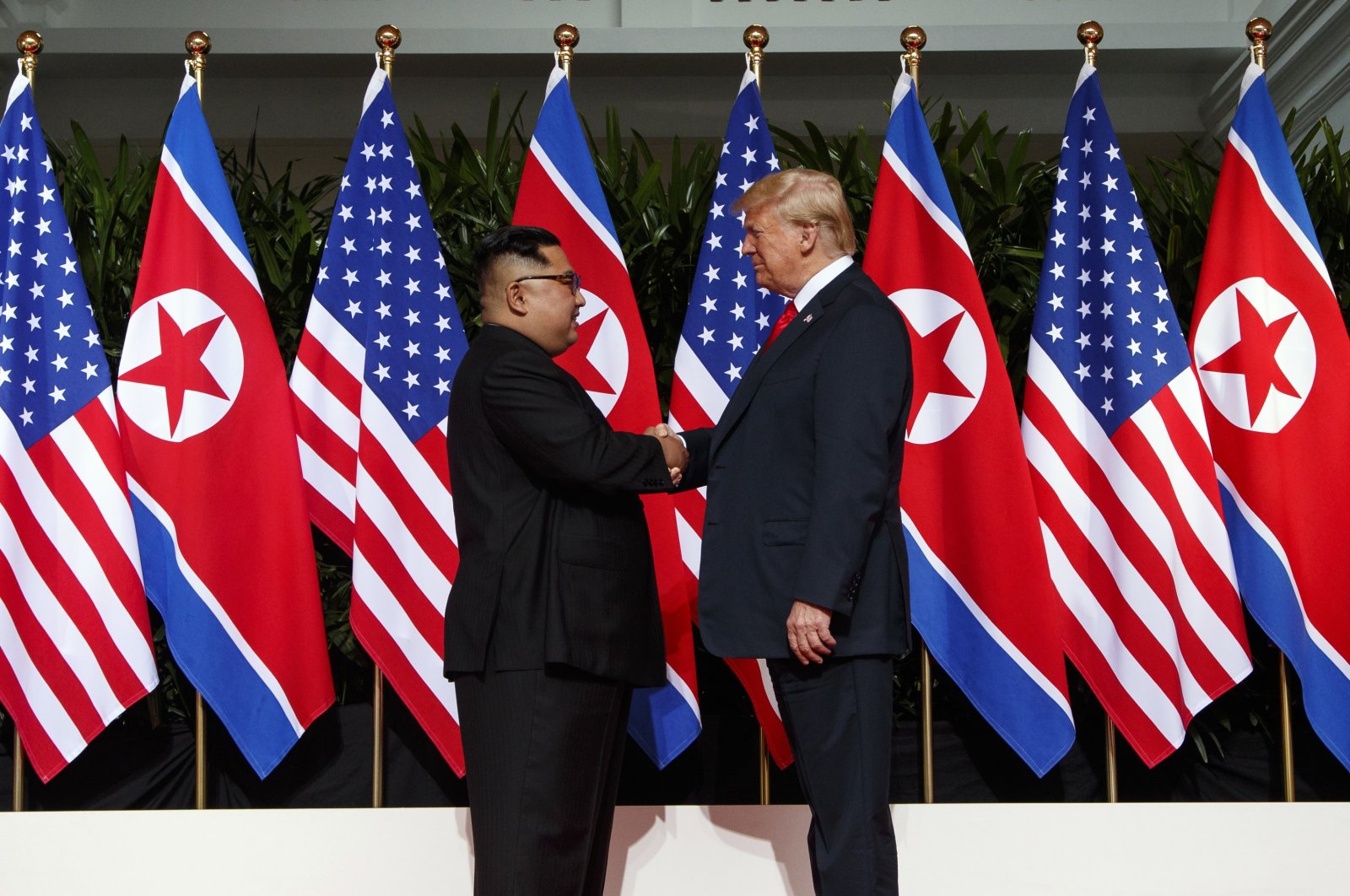 North Korean leader Kim Jong Un (L) and U.S. President Donald Trump shake hands prior to their meeting on Sentosa Island in Singapore on June 12, 2018. (AP File Photo)