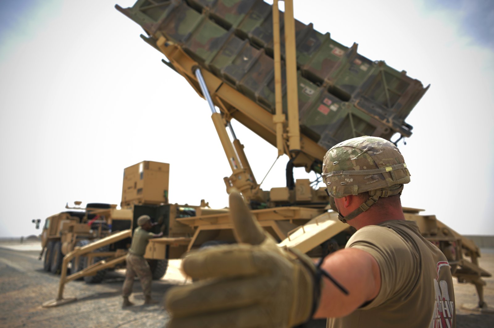 In this photo released by the U.S. Air Force, U.S. Army Spc. Scottlin Bartlett of the 5-52 Air Defense Artillery Battalion signals to a colleague while working near a Patriot missile battery at Al-Dhafra Air Base in Abu Dhabi, United Arab Emirates, May 5, 2021. (AP Photo)