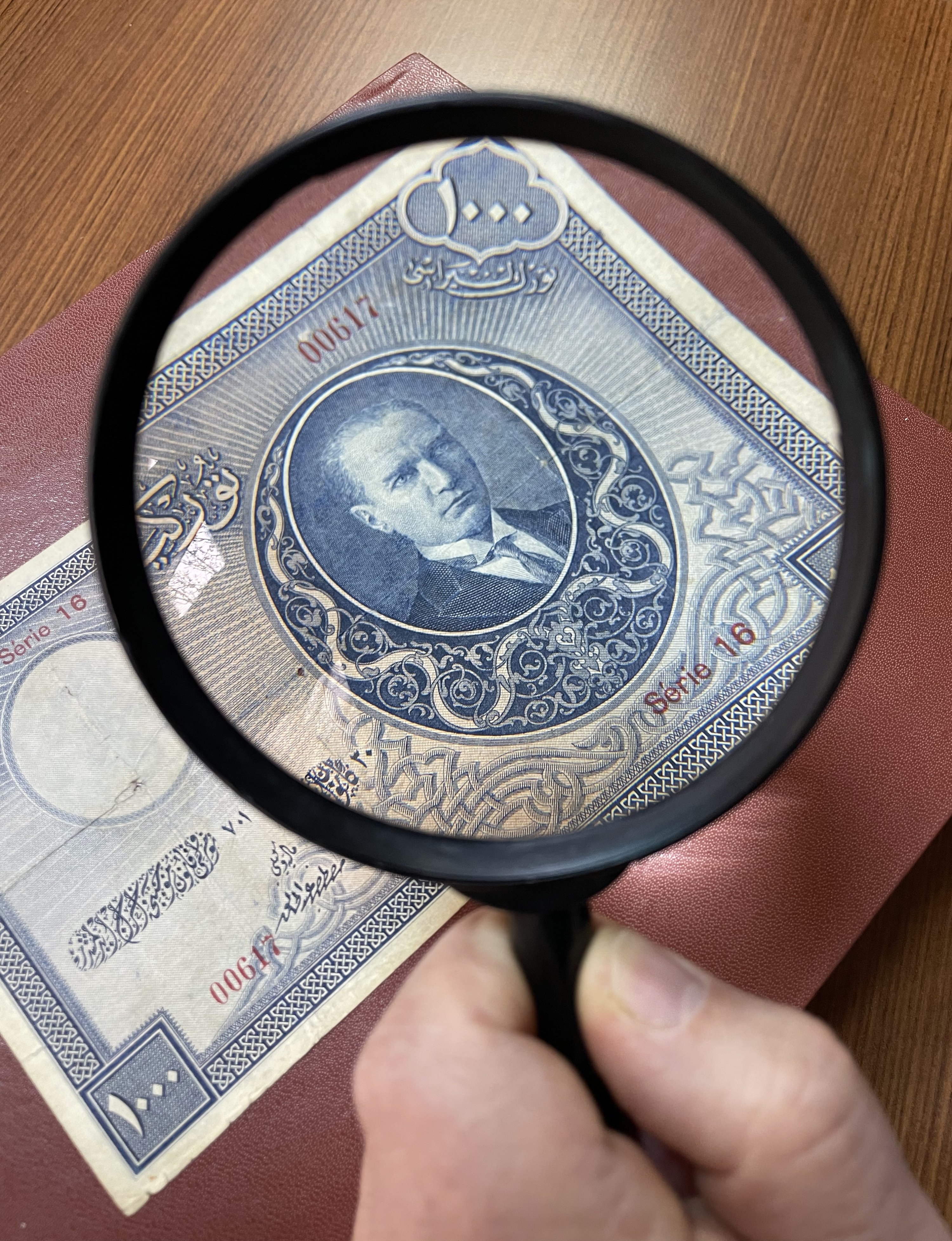 A view of the first emission TL 1,000 banknote is seen through a magnifying glass, Ankara, Turkey, Feb. 10, 2022. (AA)