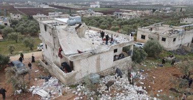 An aerial picture taken by a drone shows people inspecting a damaged building after an alleged counterterrorism operation by U.S. special forces in the early morning in Atmeh village in the northern countryside of Idlib, Syria, Feb. 3, 2022. (EPA Photo)