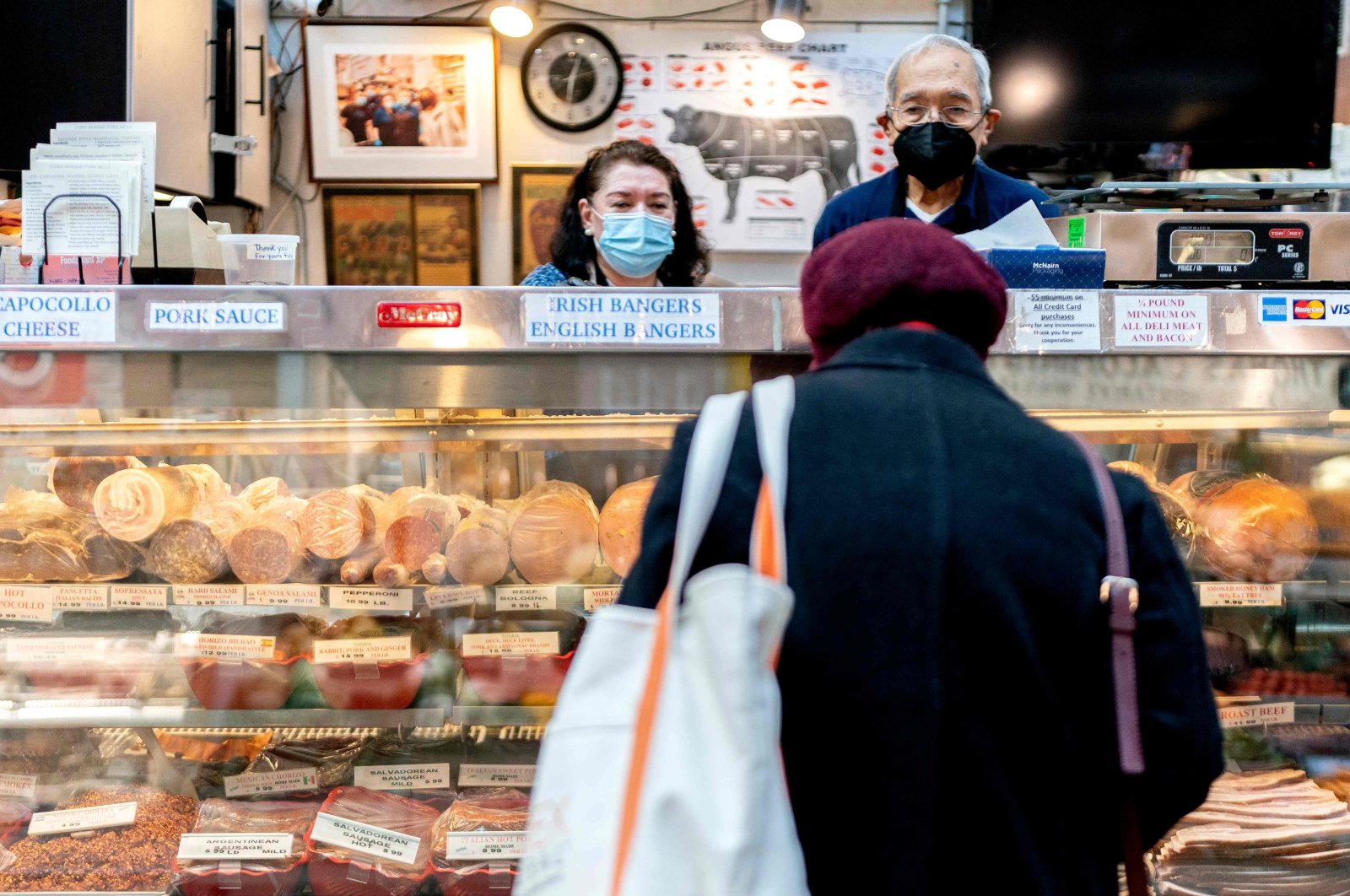 Employees assist a customer at Canales Quality Meats in Eastern Market in Washington, D.C., U.S., Feb. 8, 2022. (AFP Photo)