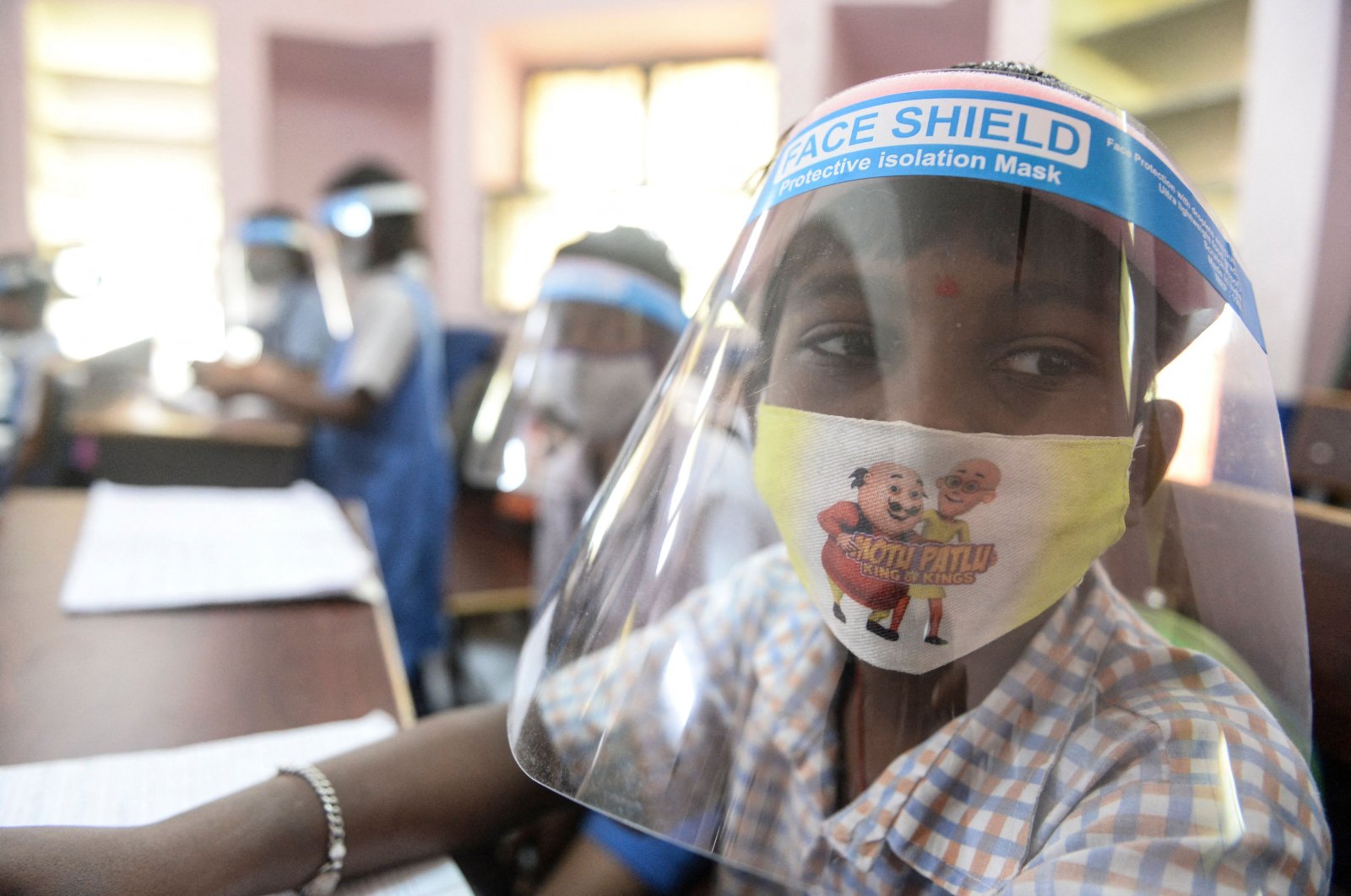 A student wearing facemasks and face-shield attends a class after the reopening of schools closed as a preventive measure to curb the spread of COVID-19, at a government girls primary school in Hyderabad, India on Feb. 11, 2022. (AFP Photo)