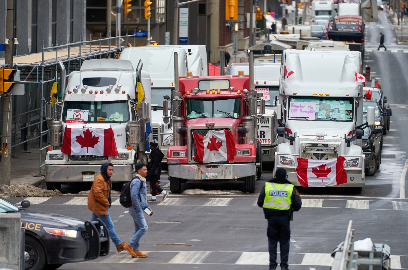 Ottawa citizens go to work as truckers block the streets near Parliament Hill during a protest against vaccine mandates in downtown Ottawa, Ontario, Canada, Feb. 2022. (EPA Photo)