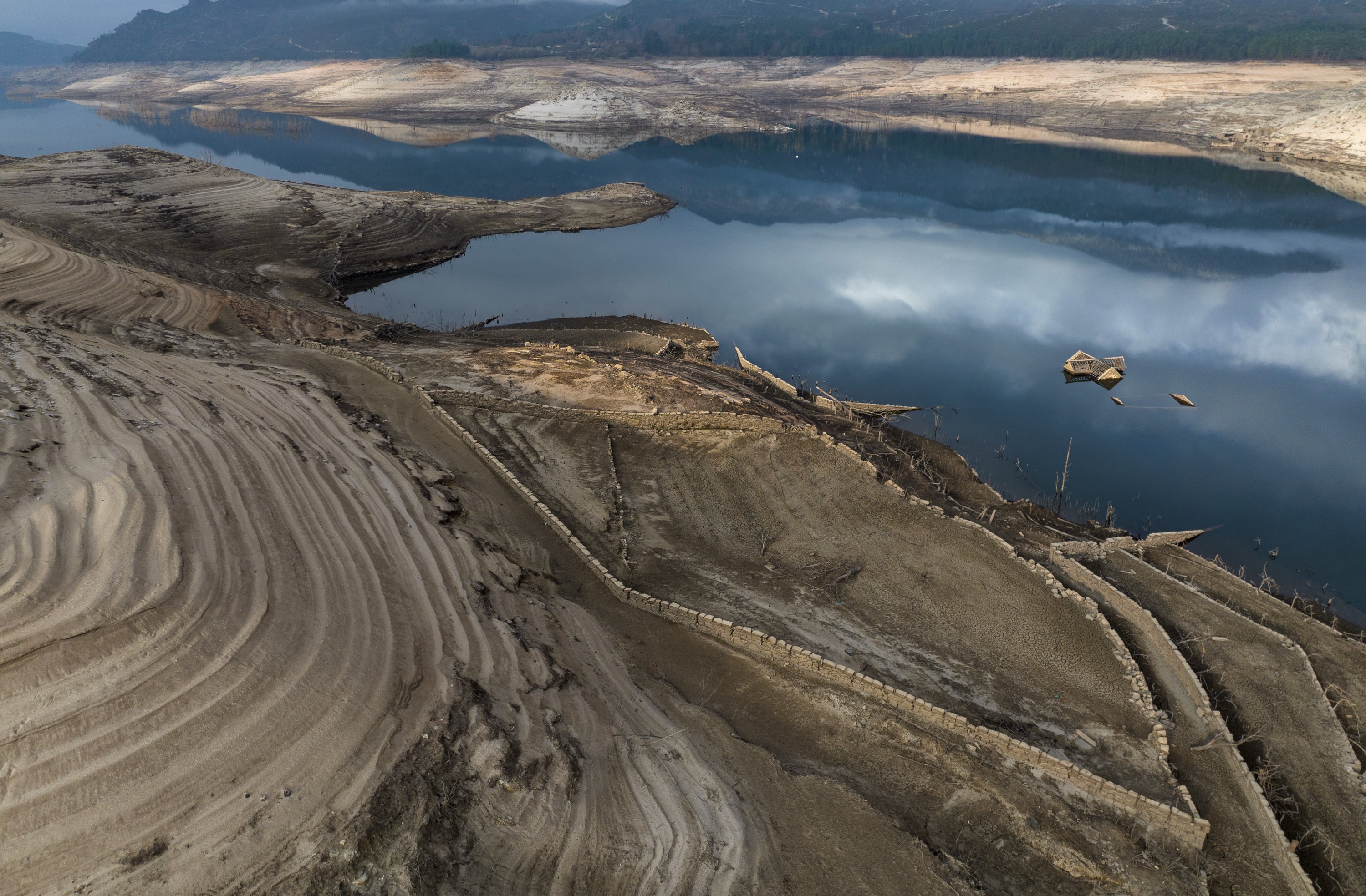 The roof of an old house, submerged three decades ago when a hydropower dam flooded the valley, is photographed emerged due to drought at the Lindoso reservoir, in northwestern Spain, Feb. 12, 2022. (AP Photo)