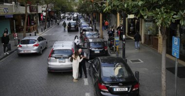 A couple hug each other as other people pass at Hamra Street, in Beirut, Lebanon, Jan. 12, 2022. (AP Photo)
