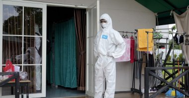 A health worker stands outside a treating room for COVID-19 patient at an isolation center in Tangerang, on the outskirts of Jakarta, Indonesia, Feb. 3, 2022. (AP Photo)