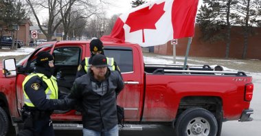 Police detain a protestor as they clear demonstrators against COVID-19 vaccine mandates who blocked the entrance to Ambassador Bridge in Windsor, Ontario, Canada, Feb. 13, 2022. (AFP Photo)