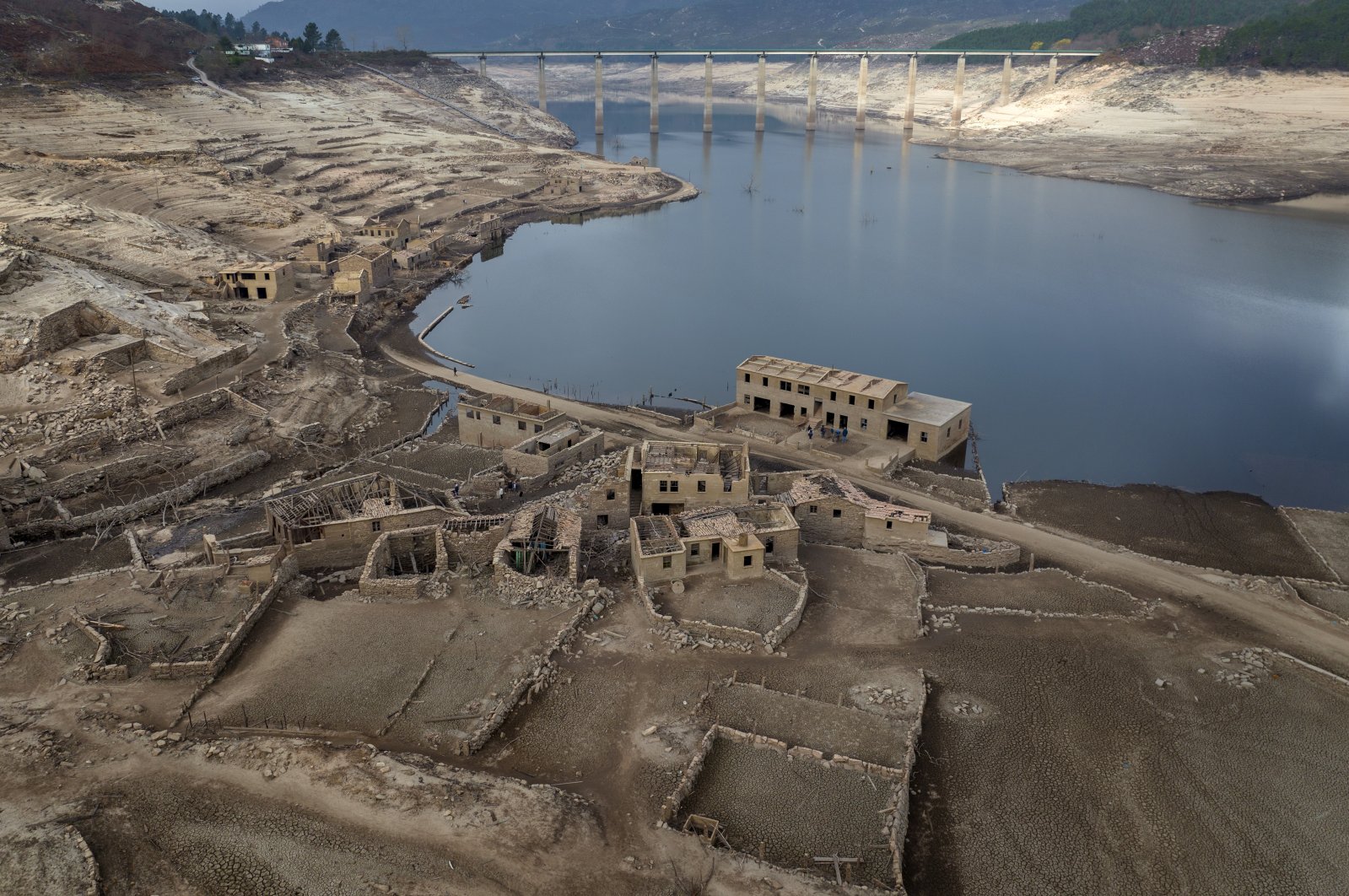 Parts of the old village of Aceredo, submerged three decades ago when a hydropower dam flooded the valley, are photographed emerging due to drought at the Lindoso reservoir, in northwestern Spain, Feb. 12, 2022. (AP Photo)