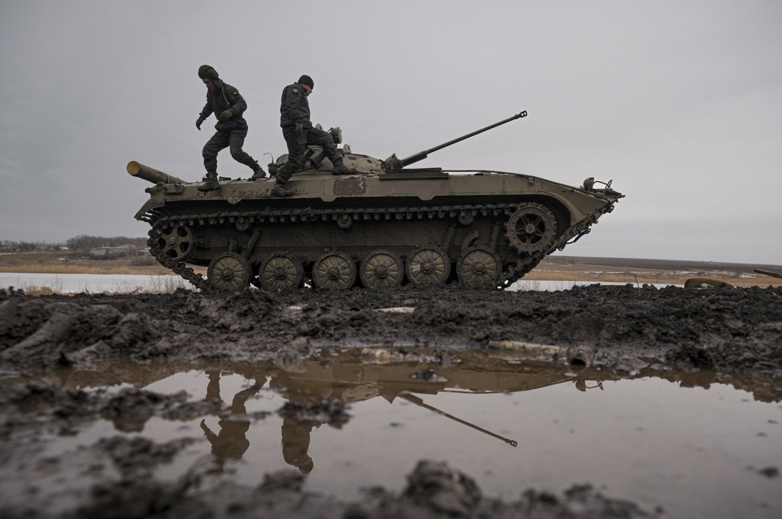 Ukrainian service officers walk on an armored vehicle during an exercise in a Joint Forces Operation-controlled area in the Donetsk region, eastern Ukraine, Feb. 10, 2022. (AP Photo)