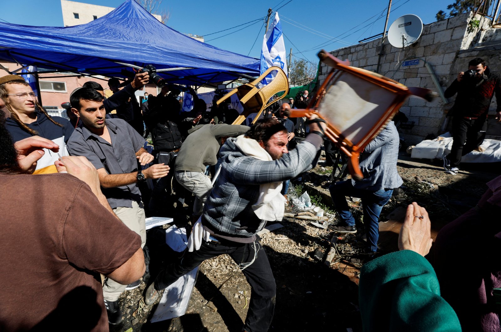 Jewish settlers hurling chairs at Palestinian protesters (not shown) in Sheikh Jarrah, East Jerusalem, occupied Palestine, Feb. 13, 2022. (Reuters Photo)