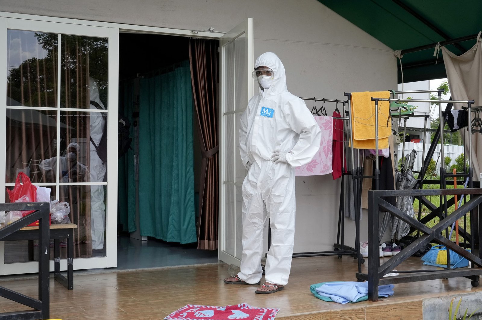 A health worker stands outside a treating room for COVID-19 patient at an isolation center in Tangerang, on the outskirts of Jakarta, Indonesia, Feb. 3, 2022. (AP Photo)