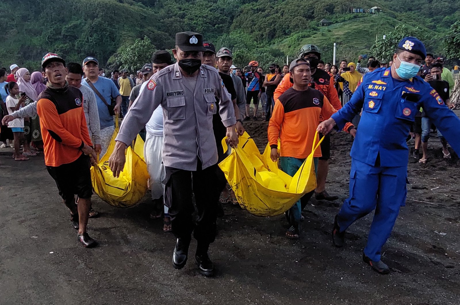 Indonesian members of a search and rescue team transport dead bodies during a search operation following a beach ritual accident that killed 11 people in Jember, East Java, Indonesia, Feb. 13, 2022. (AFP Photo)