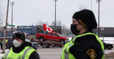 Police officers move along a road leading to the Ambassador Bridge, which connects Detroit and Windsor, after clearing demonstrators, during a protest against COVID-19 vaccine mandates, in Windsor, Ontario, Canada, Feb. 13, 2022. (Reuters Photo)