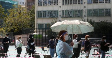 People wearing face masks queue at a makeshift testing center for the coronavirus following the outbreak in Hong Kong, Feb. 14, 2022. (Reuters Photo)
