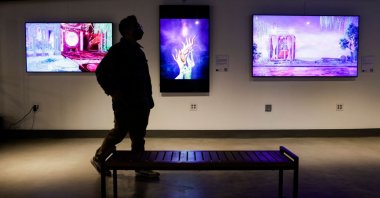 A visitor walks among artwork on display during the opening weekend of the Seattle NFT Museum in Seattle, Washington, U.S., Jan. 29, 2022. (AFP Photo)