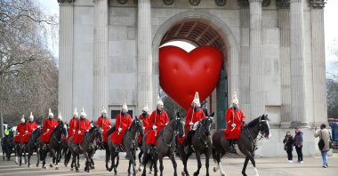 Members of the Household Cavalry walk past Wellington Arch and a large inflatable heart on Valentine's Day in London, U.K., Feb. 14, 2022. (Reuters Photo)