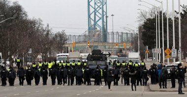 Police gather to disperse protestors against Covid-19 vaccine mandates who blocked the entrance to the Ambassador Bridge in Windsor, Ontario, Canada, Feb. 13, 2022. (AFP)