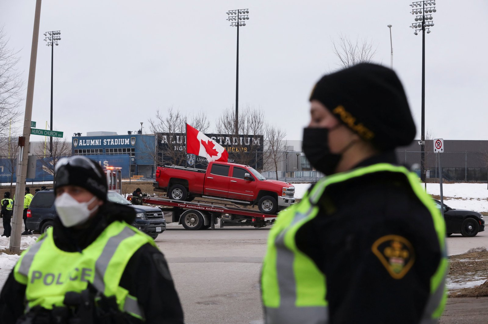 Police officers move along a road leading to the Ambassador Bridge, which connects Detroit and Windsor, after clearing demonstrators, during a protest against COVID-19 vaccine mandates, in Windsor, Ontario, Canada, Feb. 13, 2022. (Reuters Photo)