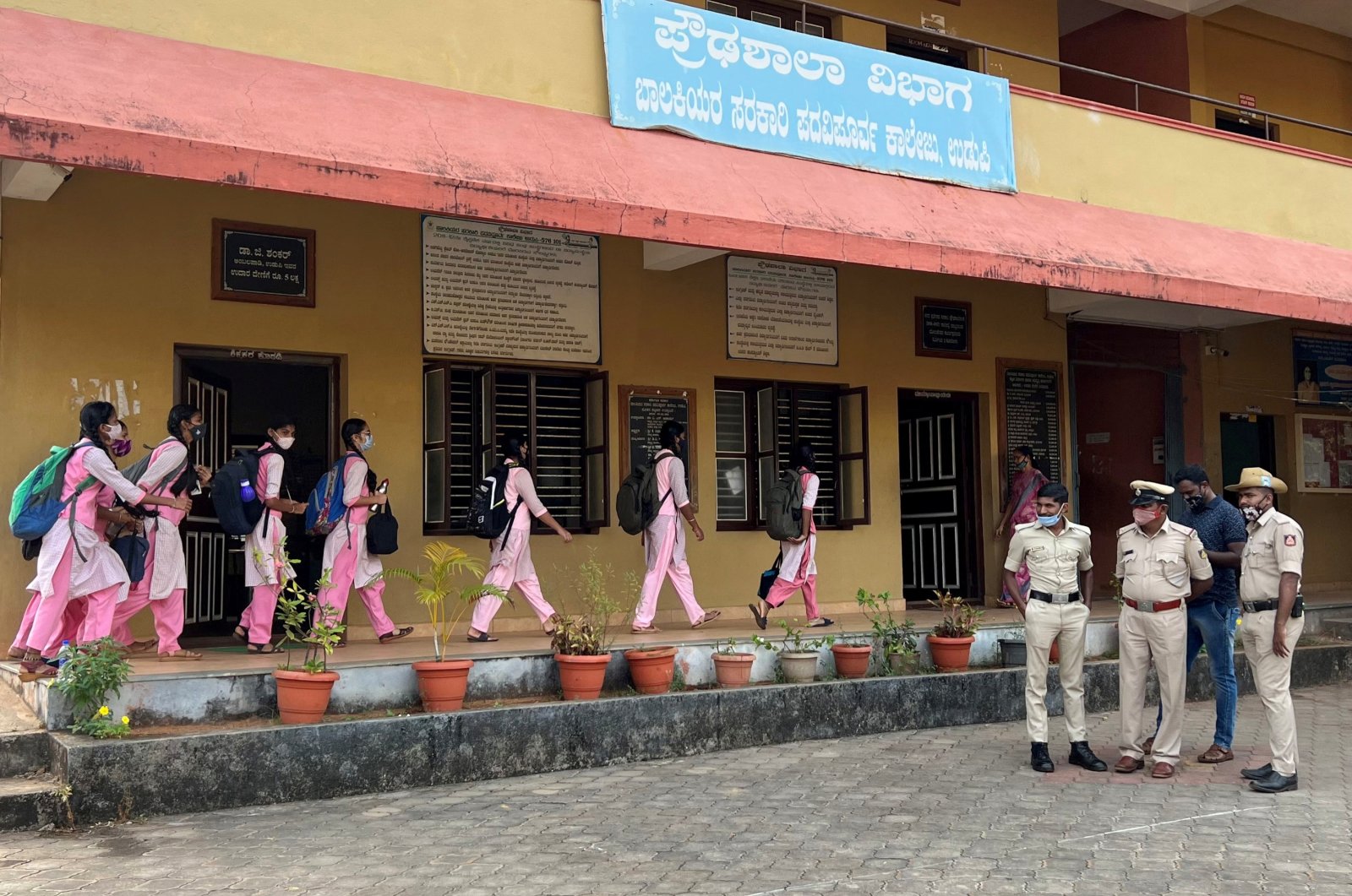 Schoolgirls arrive to attend classes as police officers stand inside the premises of a government girls school after the recent hijab ban, in Udupi town in the southern state of Karnataka, India, Feb. 14, 2022. (Reuters Photo)