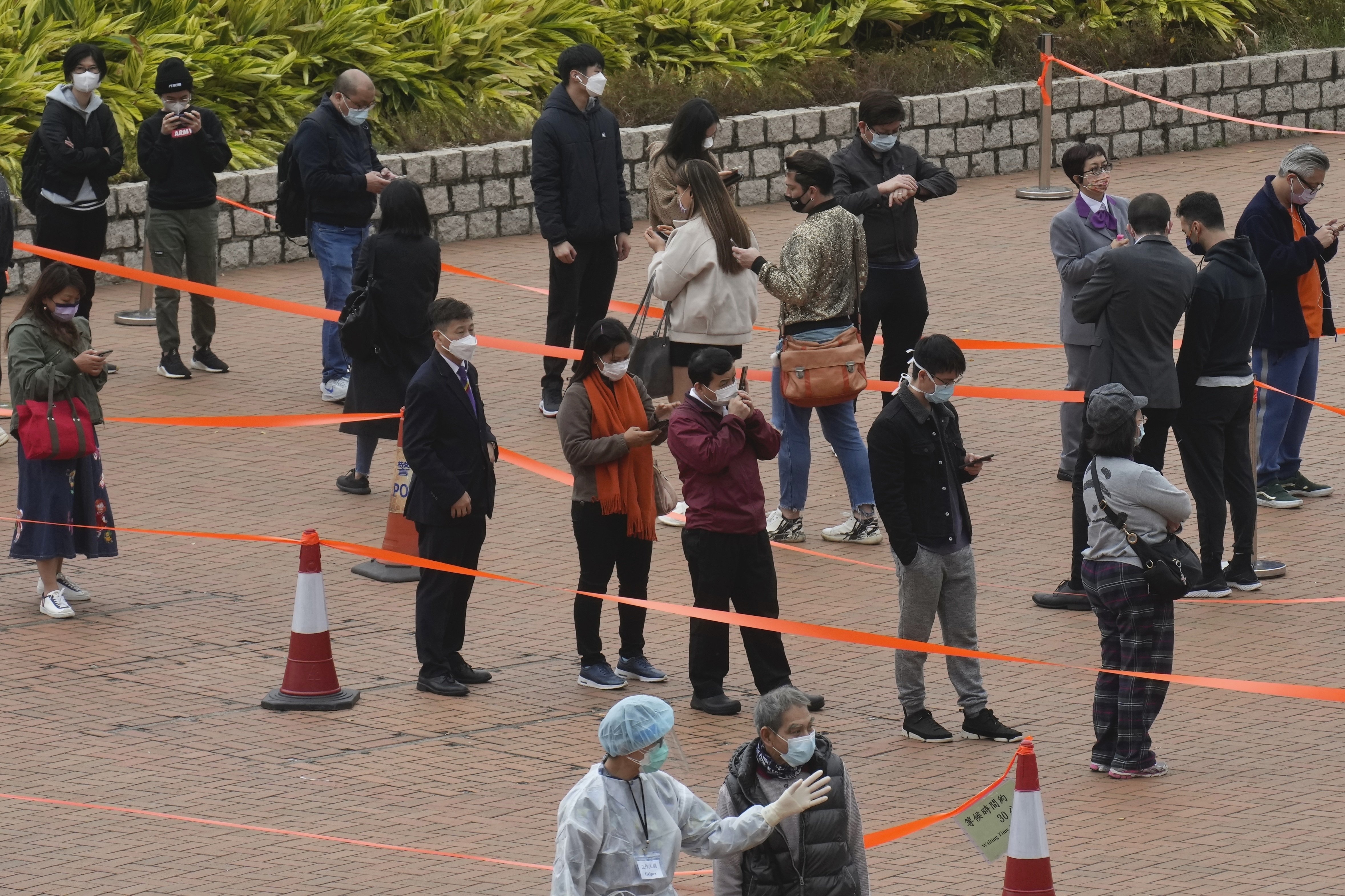 Residents queue up to get tested for the coronavirus at a temporary testing center for COVID-19 in Hong Kong, Feb. 13, 2022. (AP Photo)