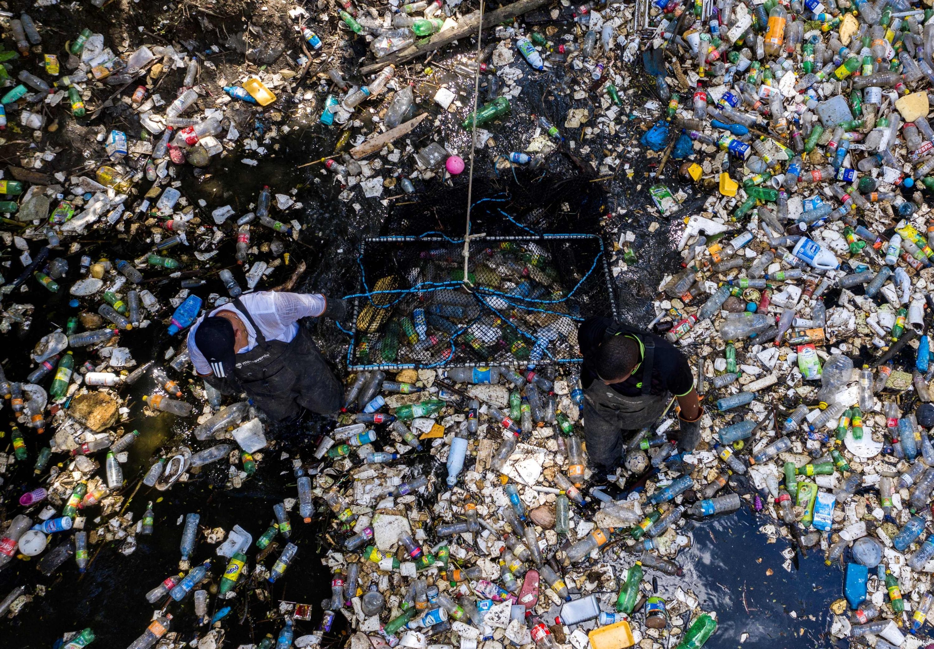 Workers collect garbage, including plastic waste, at the Matias Hernandez River in Costa del Este, Panama City, Sept. 23, 2019. (AFP Photo)