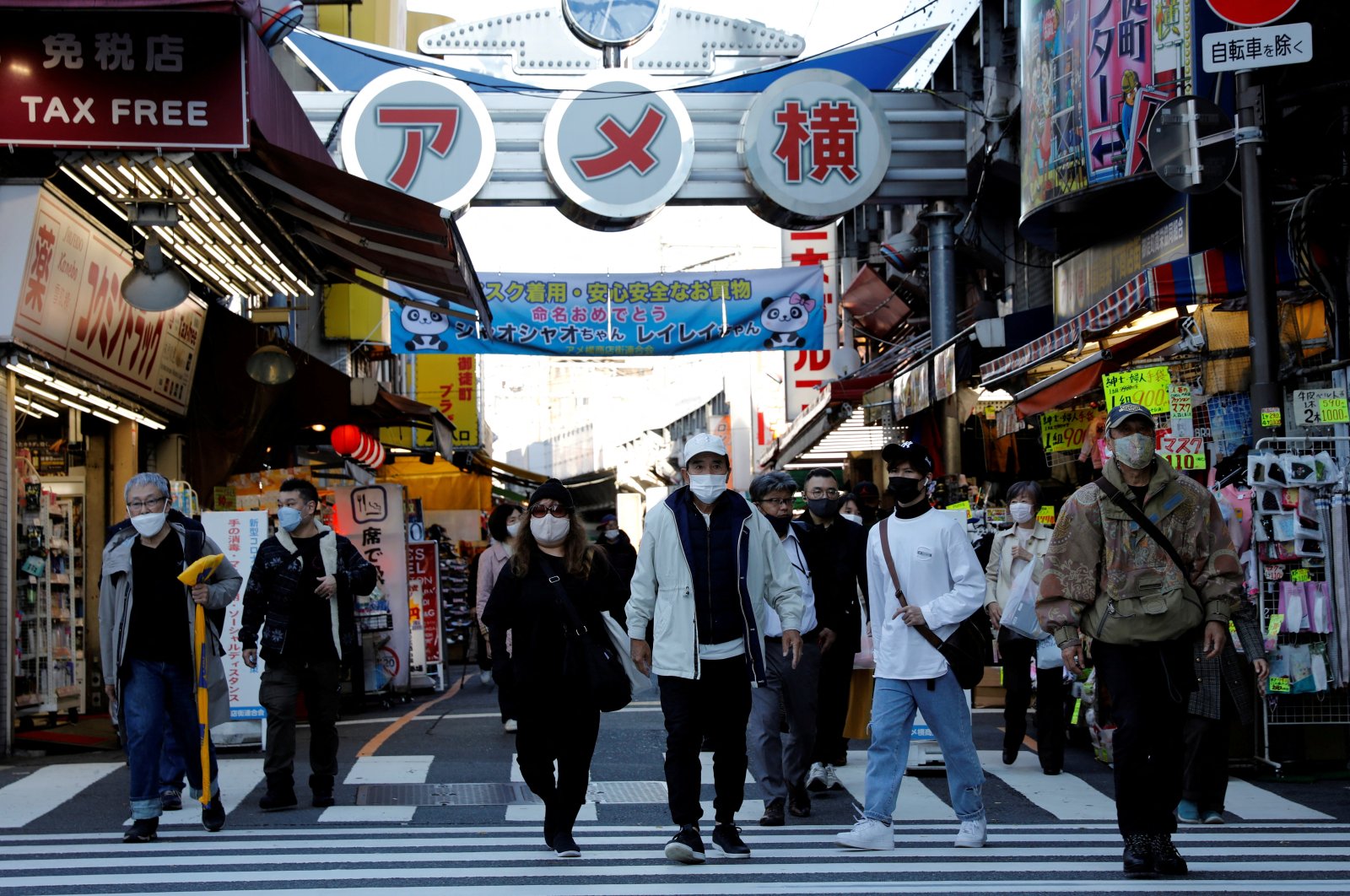 Pedestrians wearing protective masks, amid the COVID-19  outbreak, make their way at the Ameyoko shopping district in Tokyo, Japan, Dec. 1, 2021. (Reuters Photo)