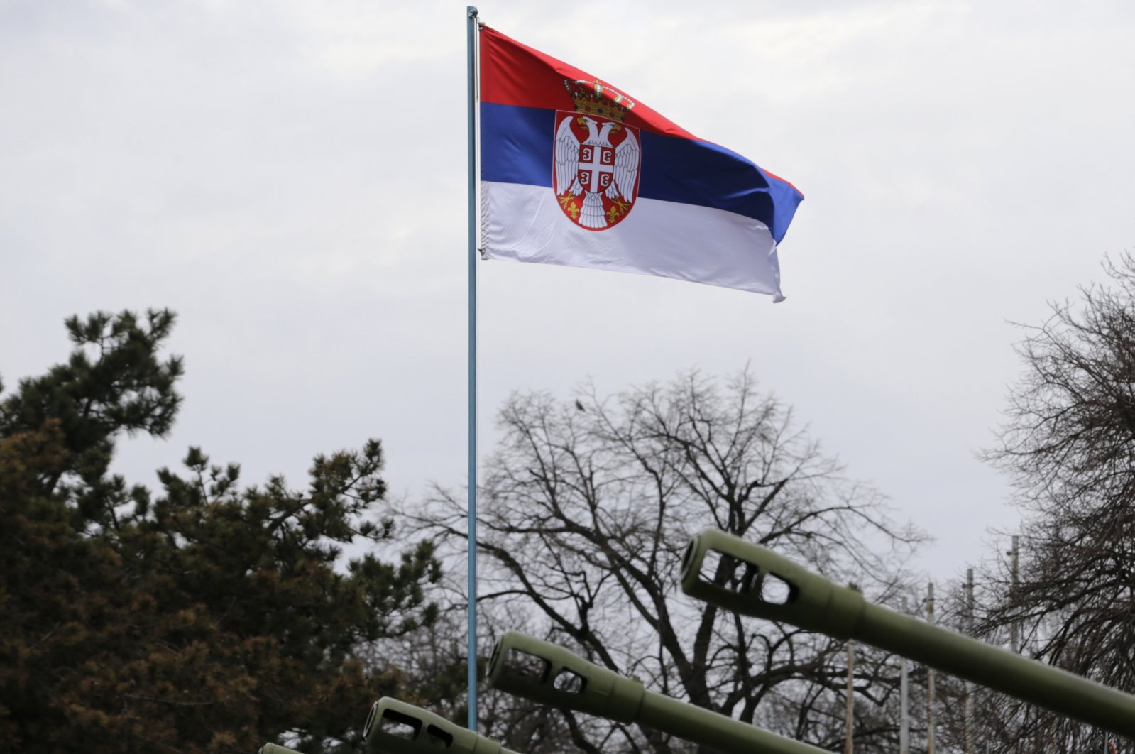 A Serbian flag flies high over the canons firing the honorary minute fire on the eve of Serbia&#039;s national day, Belgrade, Serbia, Feb. 14 , 2022. (EPA Photo)