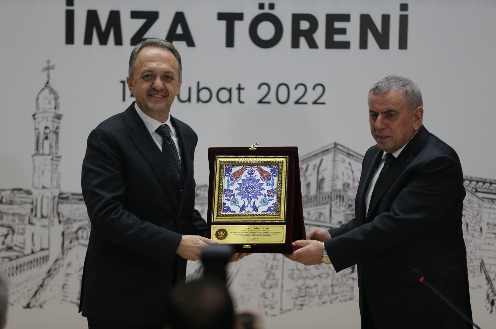 Midyat Mayor Veysi Şahin (R) gifts Cultural Heritage and Museums General Manager Gökhan Yazgı a plaque commemorating the signing of a protocol to work toward applying for a UNESCO World Heritage Temporary Listing of nine churches and monasteries, Mardin, southeastern Turkey, Feb. 14, 2022. (AA Photo)