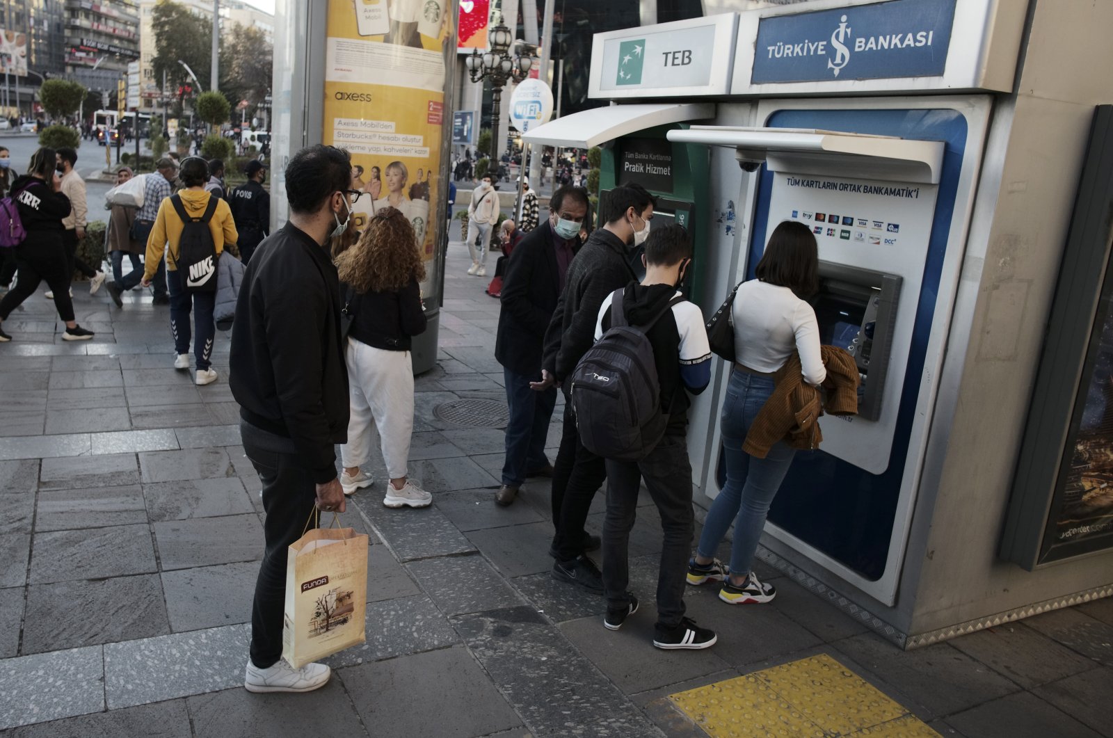 People line up to retrieve money from a bank ATM in the capital, Ankara, Turkey, Oct. 22, 2021. (AP Photo)
