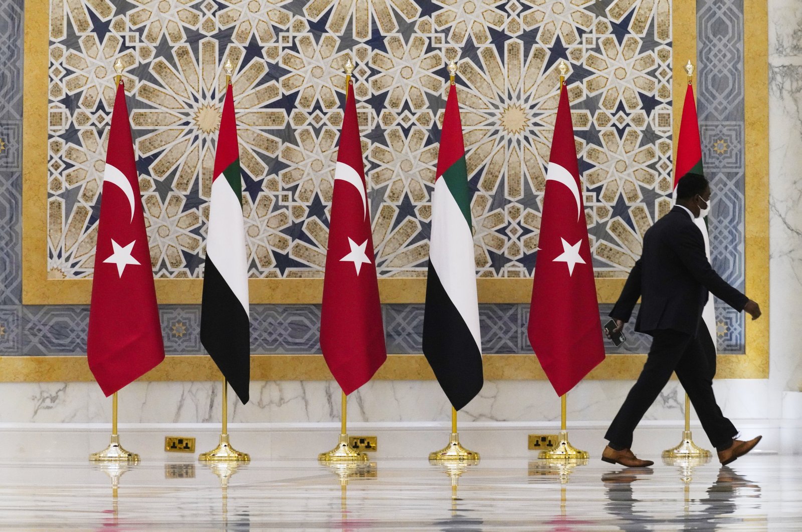 An official walks past Turkish and Emirati flags at Qasr Al-Watan in Abu Dhabi, United Arab Emirates, Monday, Feb. 14, 2022. (AP Photo)