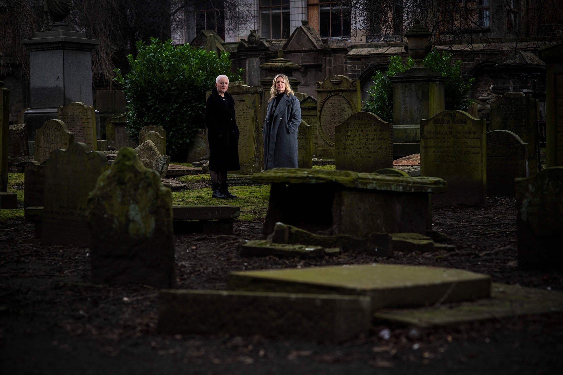 Founder of the association "Witches of Scotland" Claire Mitchell and member Zoe Venditozzi pose for pictures in the Howff Cemetery in Dundee, Scotland, Jan. 30, 2022. (AFP Photo)