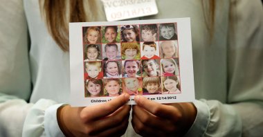 Kyra Murray holds a photo with victims of the shooting at Sandy Hook Elementary School during a press conference at the U.S. Capitol calling for gun reform legislation and marking the 9-month anniversary of the shooting in Washington, D.C., Sept.17, 2013. (AFP File Photo)
