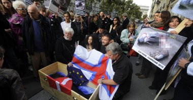 Protesters demonstrate with a dead pilot whale in a coffin and posters to denounce the massacre of pilot whales and other cetaceans around the Faroe islands, near the Danish Embassy in Paris, France, Sept. 30, 2010. (AFP Photo)