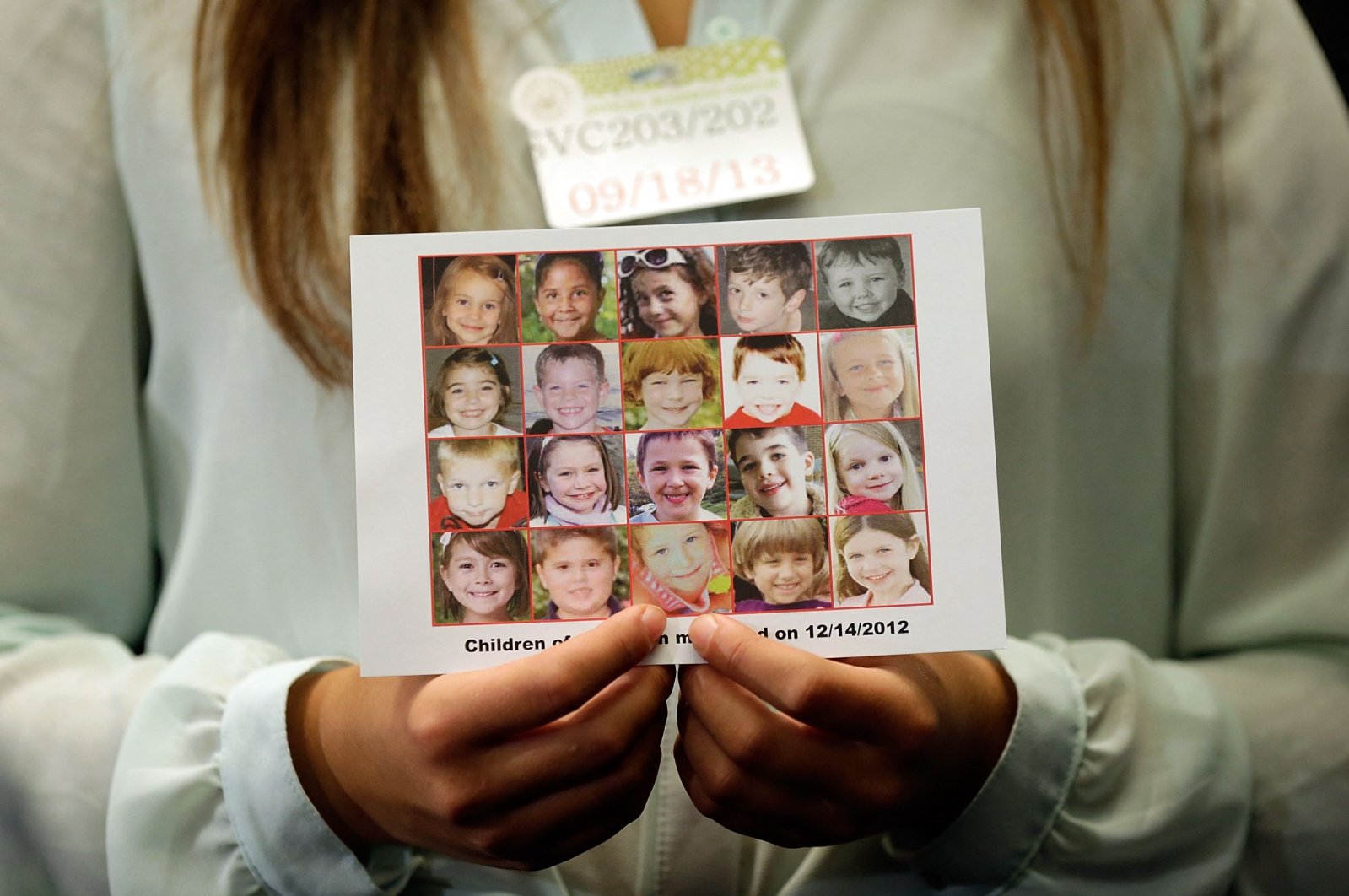 Kyra Murray holds a photo with victims of the shooting at Sandy Hook Elementary School during a press conference at the U.S. Capitol calling for gun reform legislation and marking the 9-month anniversary of the shooting in Washington, D.C., Sept.17, 2013. (AFP File Photo)