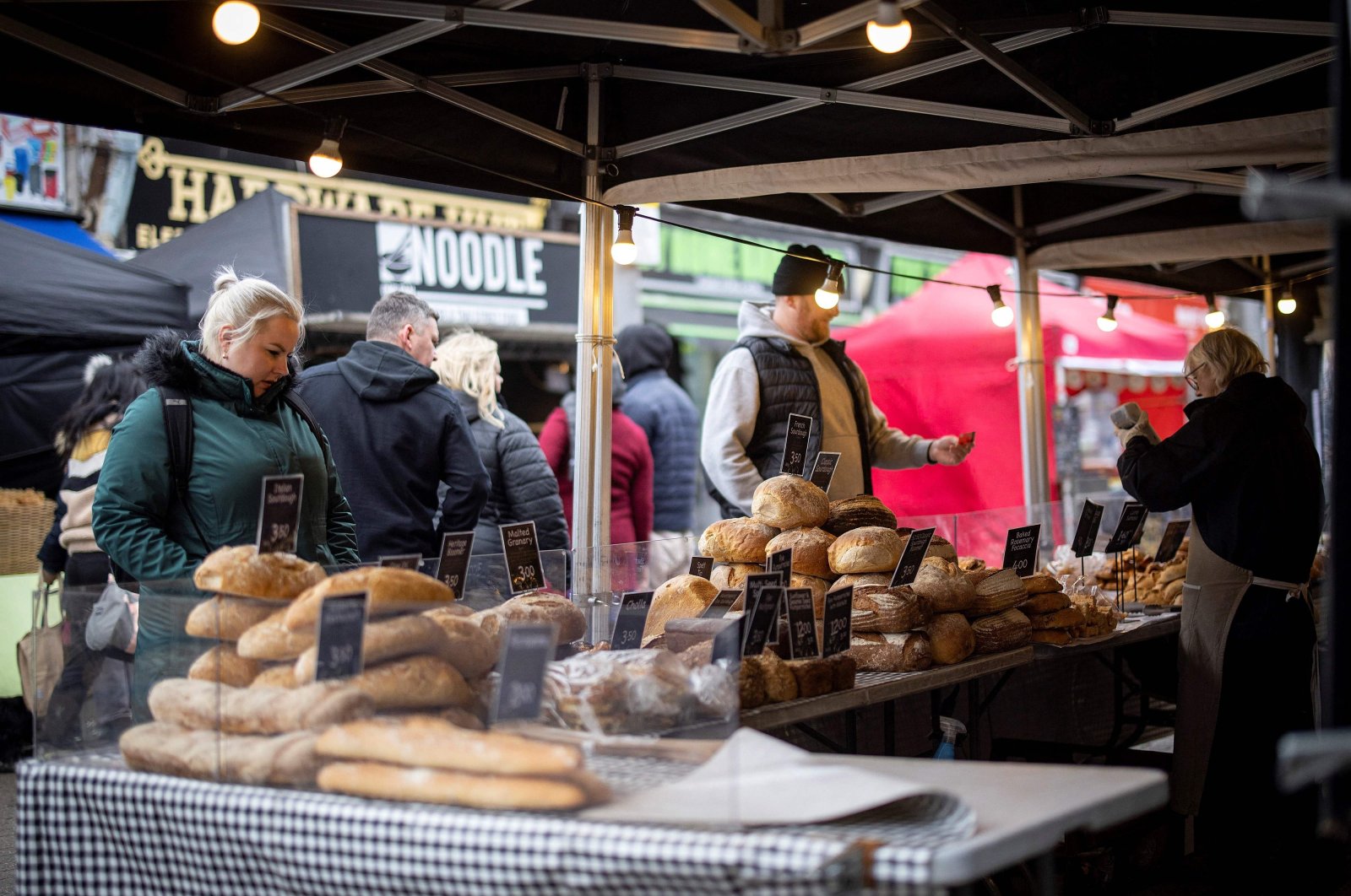 Customers shop for bread on a market stall in Walthamstow, east London, U.K., Feb. 13, 2022. (AFP Photo)