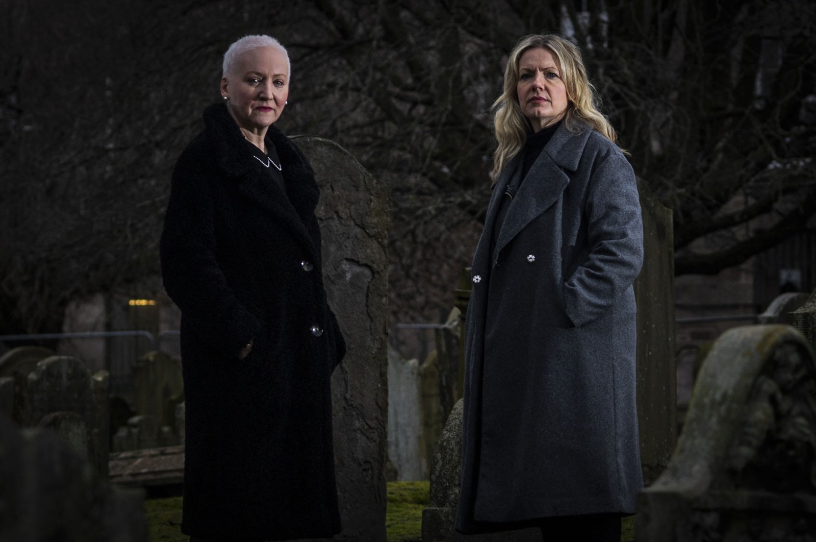 Founder of the association "Witches of Scotland" Claire Mitchell (R) and member Zoe Venditozzi pose for pictures in the Howff Cemetery in Dundee, Scotland, Jan. 30, 2022. (AFP Photo)