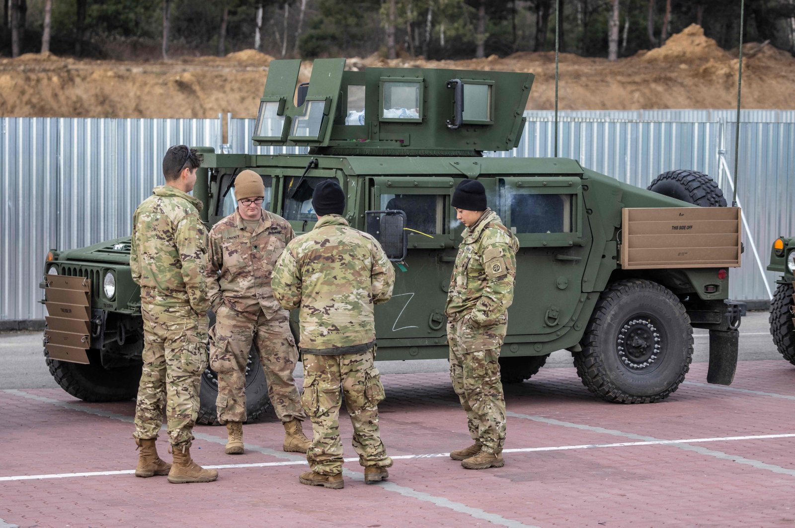 U.S. soldiers stand next to their vehicles at a temporary base installed close to the Rzeszow-Jasionka Airport, southeastern Poland, Feb. 16, 2022. (Photo by Wojtek RADWANSKI via AFP)