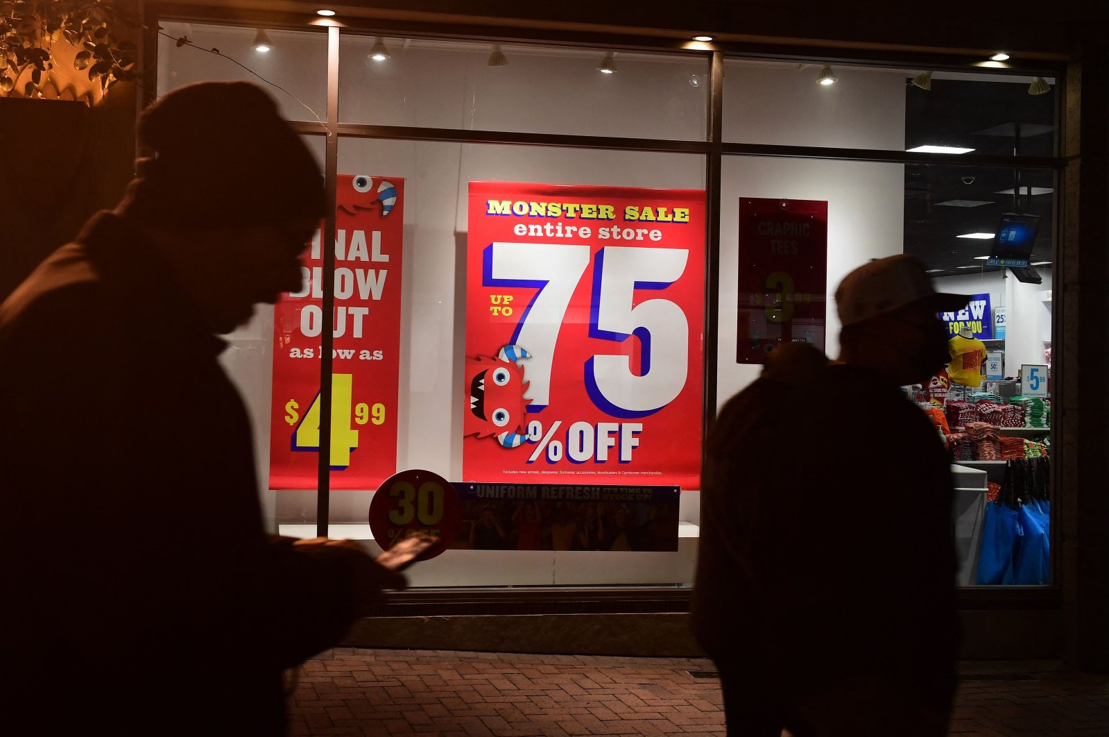 Sales signs are seen in the windows as people shop for bargains at a retail outlet in Los Angeles, California, U.S., Jan. 28, 2022. (AFP Photo)