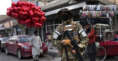 A Taliban fighter passes in front of a street vendor selling red heart-shaped balloons for Valentine&#039;s Day in Kabul, Afghanistan, Feb. 14, 2022. (AP Photo)