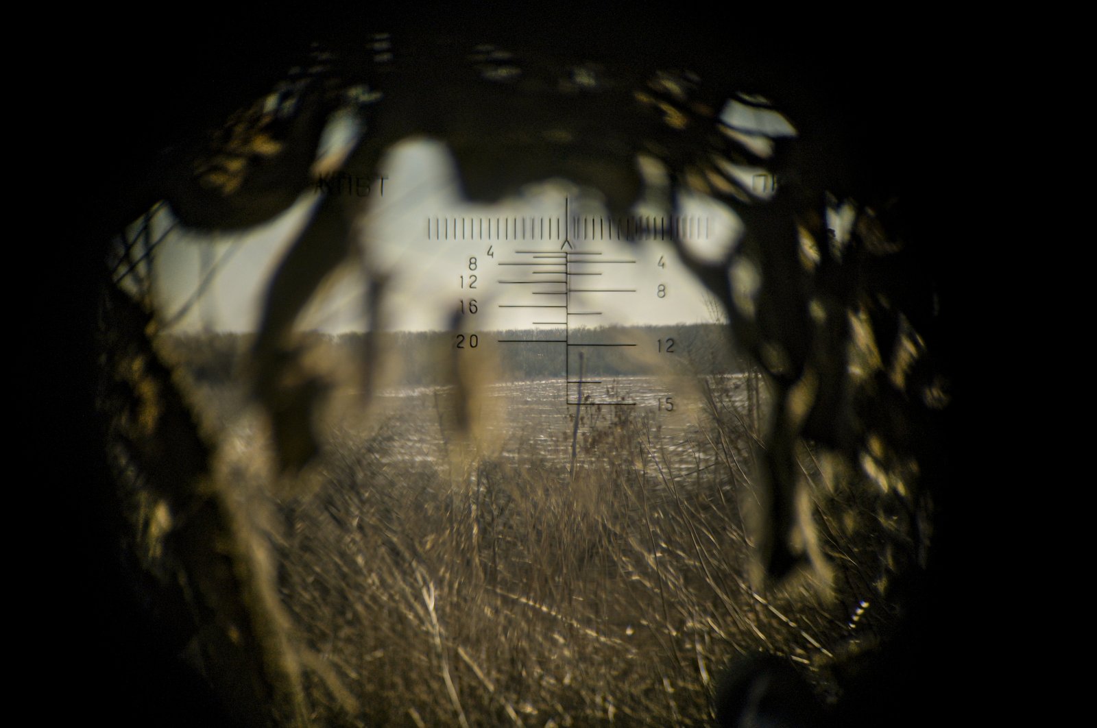 Land is seen through a machine gun spotting optic, outside Popasna, Luhansk region, eastern Ukraine, Feb. 14, 2022. (AP Photo)