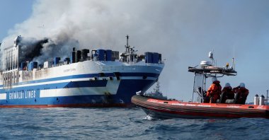 Rescuers watch as smoke rises from the burning Italian-flagged Euroferry Olympia, after a fire broke out on the ferry, off the island of Corfu, Greece, Feb. 18, 2022. (REUTERS Photo)