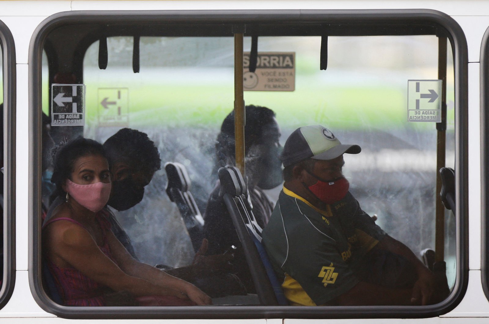 A woman wearing a protective mask, looks through the window of a bus at the central bus station in Brasilia, Brazil, Feb. 16, 2022. (Reuters Photo)