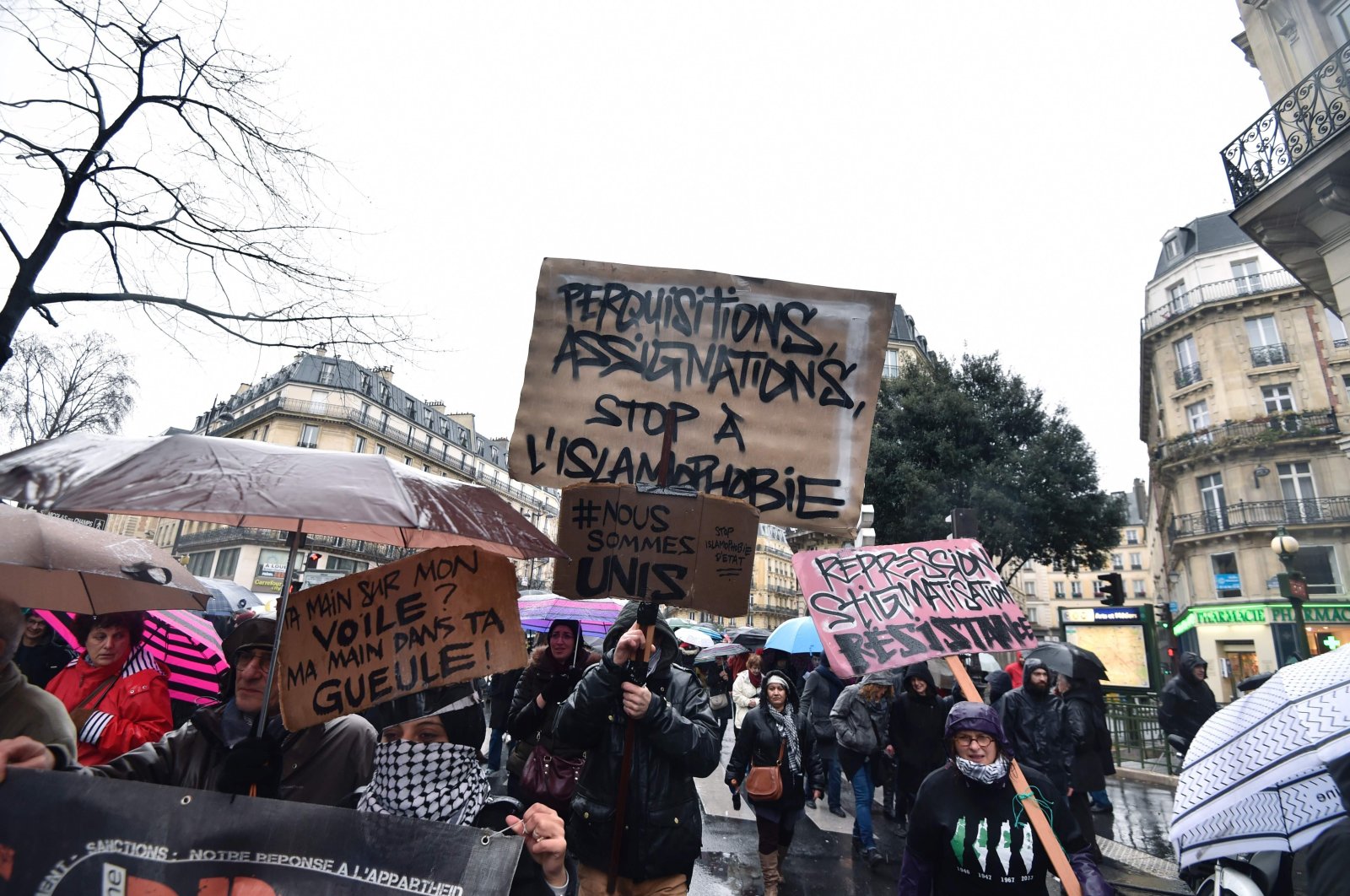 People holding banners written, "searches, summons, stop to the Islamophobia" in a demonstration that took place in Paris, France, Jan. 30, 2016. (AFP Photo)