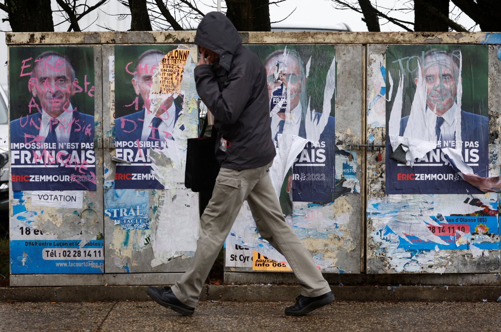 A man walks past torn campaign posters in support of Eric Zemmour, French commentator, leader of far-right party &quot;Reconquete&quot; and candidate for the 2022 French presidential election, in Les Sables d&#039;Olonne, France, Feb. 16, 2022. (REUTERS Photo)