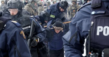 Canadian police officers detain a protester, as they work to restore normality to the capital while trucks and demonstrators continue to occupy the downtown core for more than three weeks to protest against pandemic restrictions in Ottawa, Ontario, Canada, Feb. 19, 2022. (Reuters Photo)