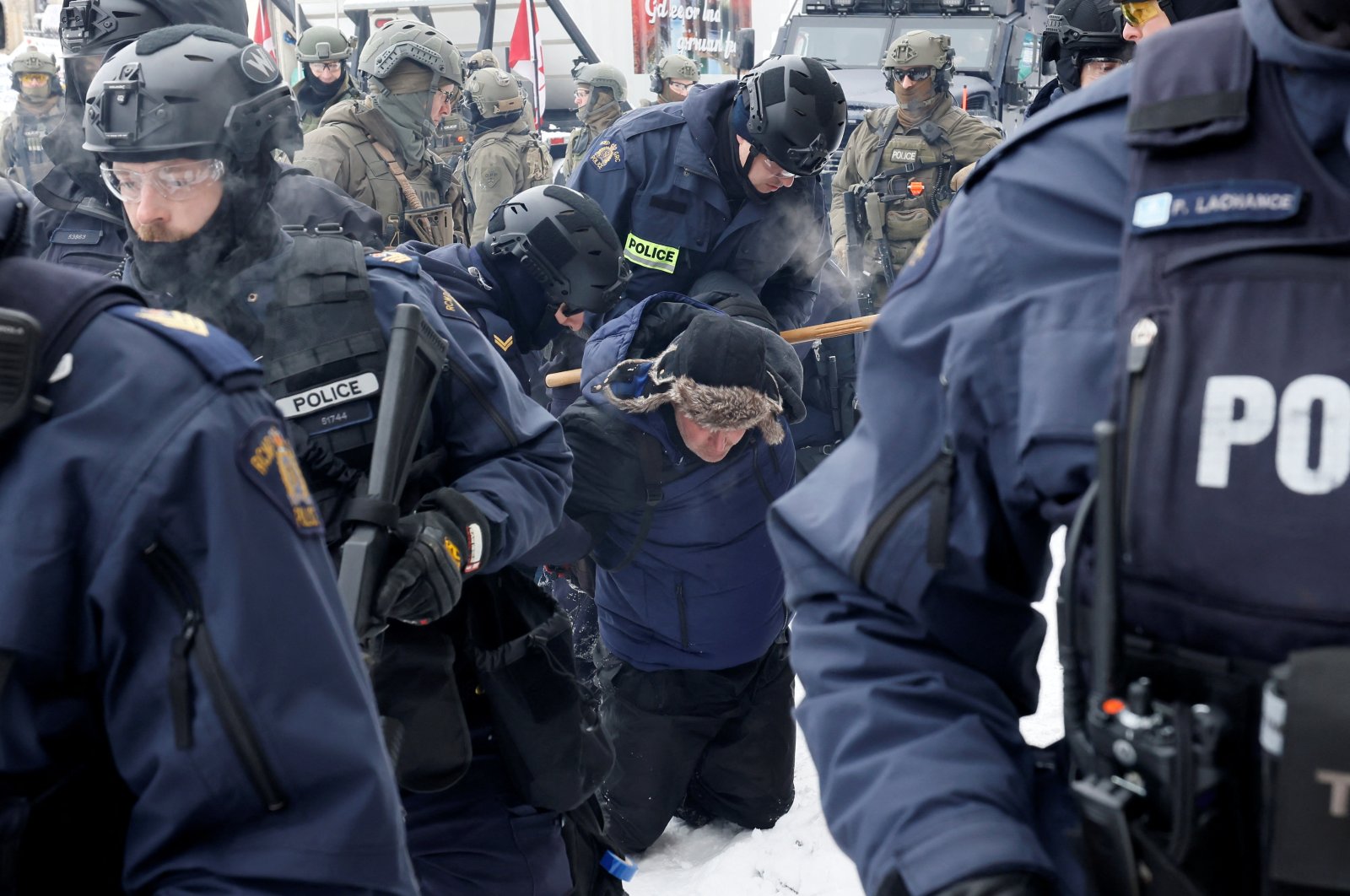 Canadian police officers detain a protester, as they work to restore normality to the capital while trucks and demonstrators continue to occupy the downtown core for more than three weeks to protest against pandemic restrictions in Ottawa, Ontario, Canada, Feb. 19, 2022. (Reuters Photo)