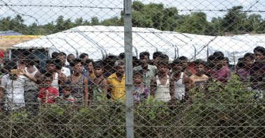 Rohingya refugees gather near a fence during a government organized media tour, to a no man's land between Myanmar and Bangladesh, near Taungpyolatyar village, Maung Daw, northern Rakhine State, Myanmar, June 29, 2018. (AP Photo)