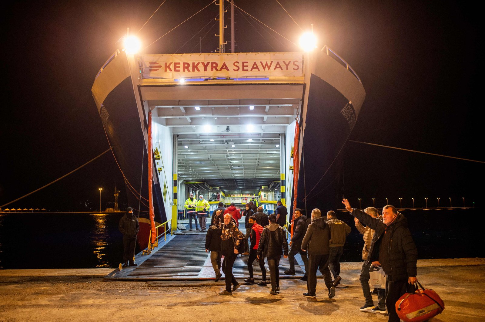 Turkish nationals wave as they board a ferry on their way to Turkey on the Greek Ionian island of Corfu on Feb. 19, 2022, after being rescued from the Italian-flagged Euroferry Olympia that caught fire earlier. (AFP Photo)