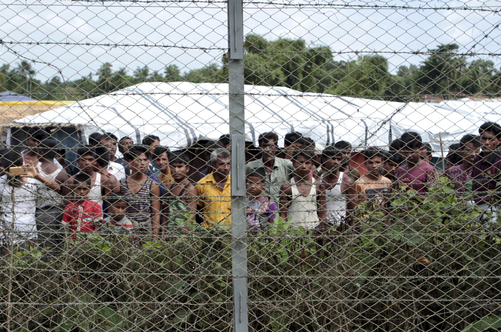 Rohingya refugees gather near a fence during a government organized media tour, to a no man&#039;s land between Myanmar and Bangladesh, near Taungpyolatyar village, Maung Daw, northern Rakhine State, Myanmar, June 29, 2018. (AP Photo)